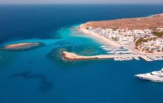 Aerial view of Ibiza coastline with beaches and crystal clear waters showing why many ask is Ibiza expensive