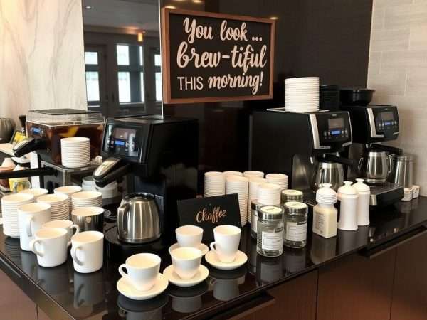 A coffee station at a breakfast buffet with a sign featuring a pun about being 'brew-tiful' A coffee station at a breakfast buffet with a sign featuring a pun about being 'brew-tiful'