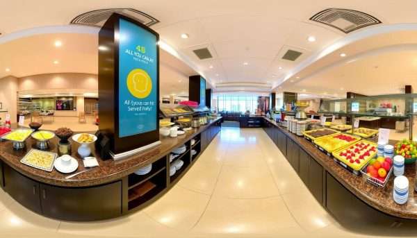 A full breakfast buffet spread with a sign featuring a pun about 'all you can eat' laughter A full breakfast buffet spread with a sign featuring a pun about 'all you can eat' laughter