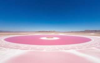 Aerial view of Utah's bright pink lake contrasting with the surrounding landscape