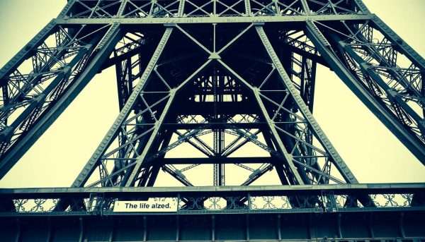 Close-up of the Eiffel Tower's iron lattice structure with pun text overlays