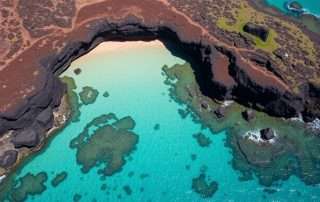 Aerial view of Two Step Beach at Honaunau Bay showing the lava rock formations and clear turquoise waters