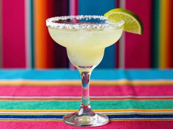 A salt-rimmed margarita glass with lime garnish A salt-rimmed margarita glass with lime garnish