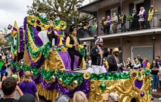 Colorful Mardi Gras parade float in New Orleans with costumed riders throwing beads to the crowd
