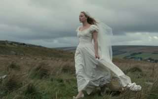 Margot Robbie in a wedding dress walking across the Yorkshire moors in the 2026 Wuthering Heights adaptation