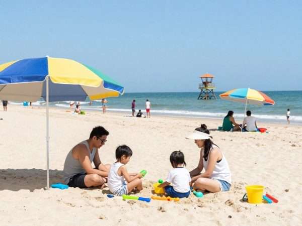 Families enjoying sunny day at Zuma Beach with umbrellas and beach toys Families enjoying sunny day at Zuma Beach with umbrellas and beach toys