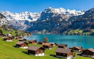 Panoramic mountain views of Swiss Alps with pristine lake and charming village
