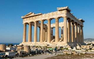 Panoramic view of Greek ruins with ancient columns against blue sky