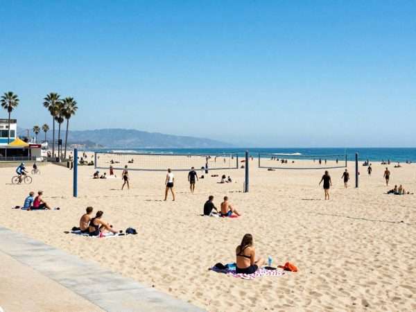 Wide sandy beach at Santa Monica with volleyball nets and beachgoers Wide sandy beach at Santa Monica with volleyball nets and beachgoers
