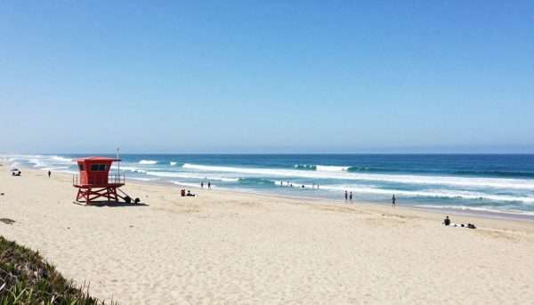 Wide sandy expanse of Zuma Beach with lifeguard tower and waves Wide sandy expanse of Zuma Beach with lifeguard tower and waves