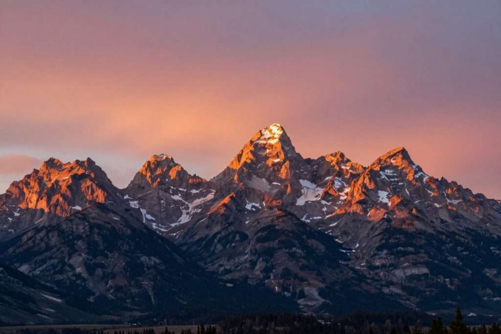 Grand Teton mountain peaks at sunrise with golden light Grand Teton mountain peaks at sunrise with golden light